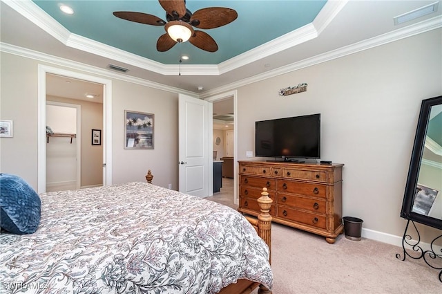 bedroom with ceiling fan, ornamental molding, and a tray ceiling