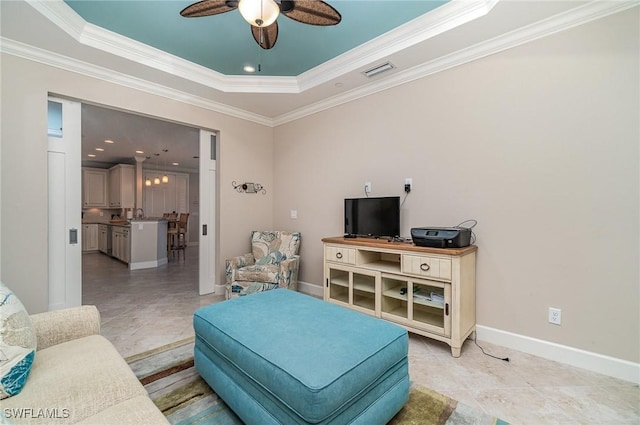 tiled living room with ceiling fan, crown molding, and a tray ceiling