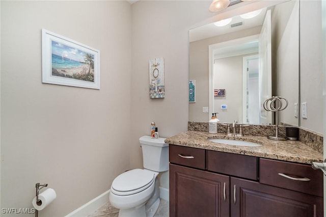 bathroom featuring tile patterned flooring, vanity, and toilet