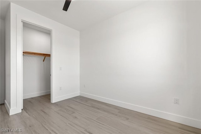 unfurnished bedroom featuring ceiling fan, light hardwood / wood-style flooring, and a closet