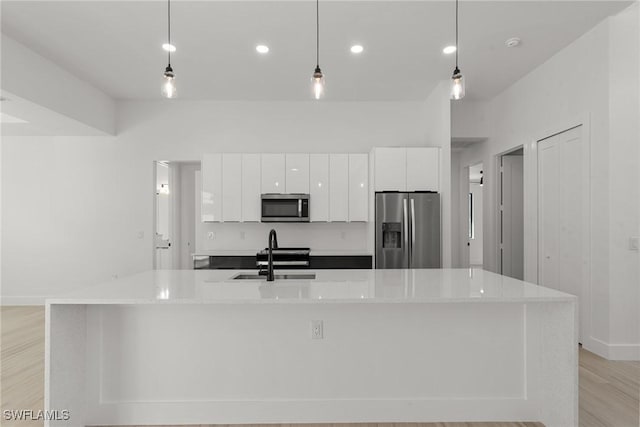 kitchen featuring a large island with sink, pendant lighting, and appliances with stainless steel finishes