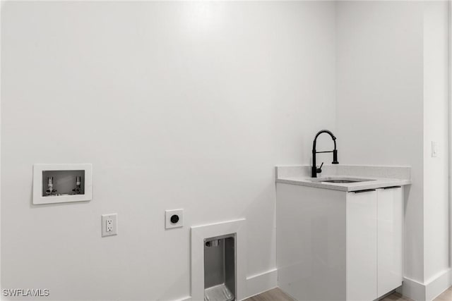 washroom featuring electric dryer hookup, cabinets, sink, washer hookup, and wood-type flooring