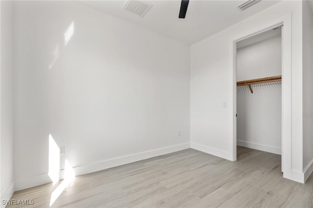 unfurnished bedroom featuring light hardwood / wood-style floors, a closet, and ceiling fan