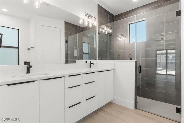 bathroom with hardwood / wood-style floors, vanity, and walk in shower