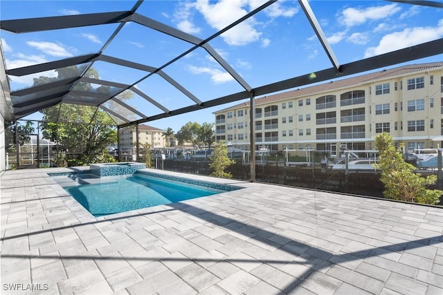 view of pool with glass enclosure, an in ground hot tub, and a patio