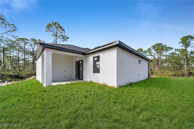 back of property featuring a yard and a patio