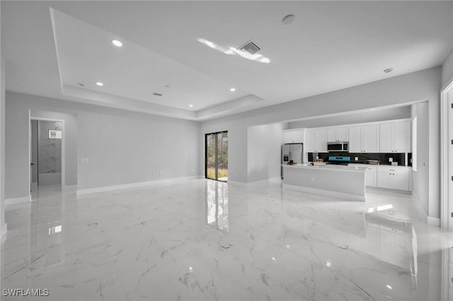 unfurnished living room featuring a tray ceiling