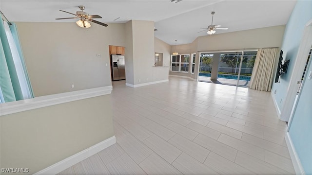 unfurnished living room featuring vaulted ceiling and ceiling fan