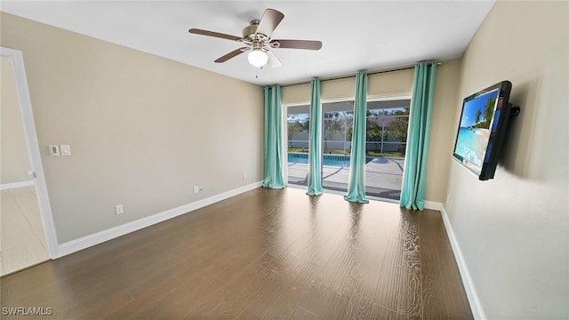 spare room with dark wood-type flooring and ceiling fan