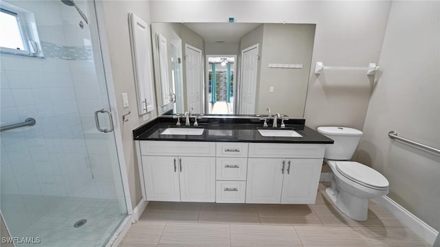 bathroom featuring a shower with door, tile patterned flooring, vanity, and toilet