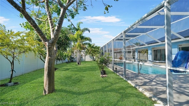 view of swimming pool featuring a yard and glass enclosure