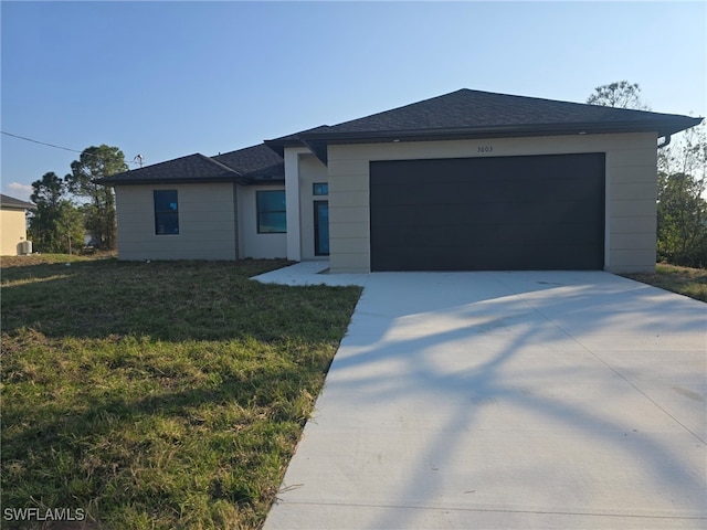 ranch-style house featuring a front yard and a garage