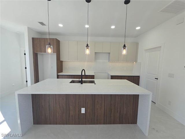 kitchen featuring sink, white cabinets, and decorative light fixtures