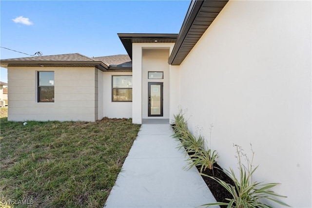 entrance to property with a lawn