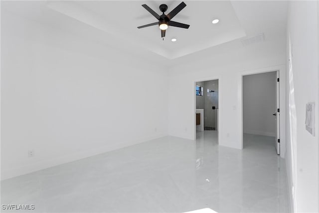 unfurnished room featuring a raised ceiling and ceiling fan