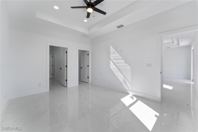 unfurnished room with a raised ceiling and ceiling fan