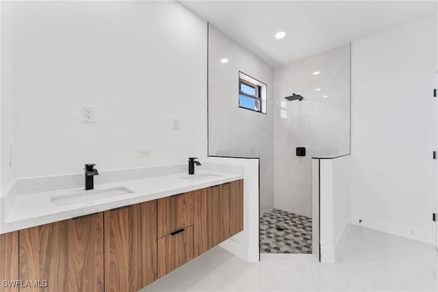 bathroom featuring tiled shower and vanity