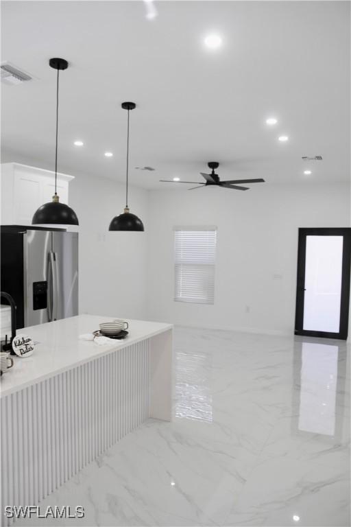 kitchen featuring marble finish floor, stainless steel refrigerator with ice dispenser, recessed lighting, visible vents, and white cabinets