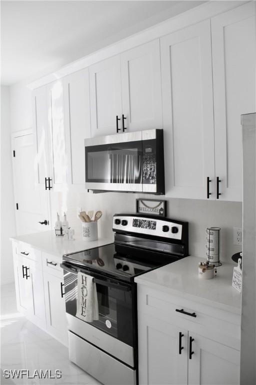 kitchen with stainless steel appliances, light countertops, and white cabinets