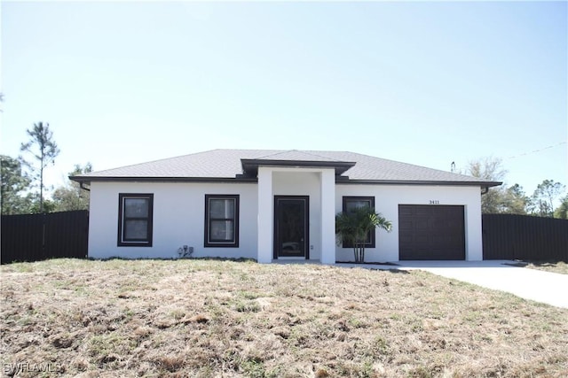 view of front of property featuring a garage, fence, concrete driveway, stucco siding, and a front lawn