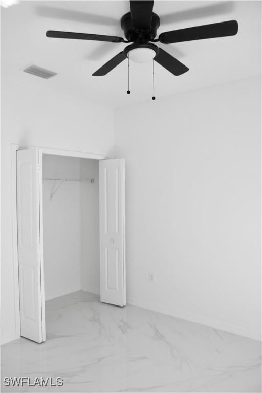 unfurnished bedroom featuring marble finish floor, a closet, visible vents, and a ceiling fan