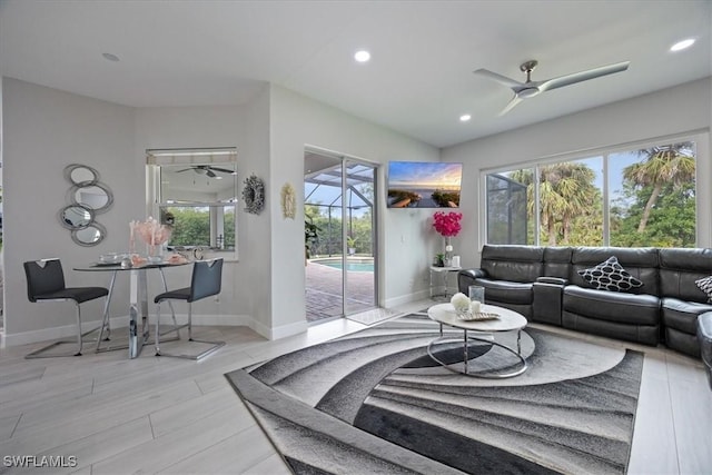 living room featuring ceiling fan, a healthy amount of sunlight, and light wood-type flooring