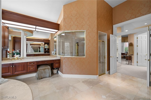 bathroom featuring decorative columns, vanity, and a shower with shower door