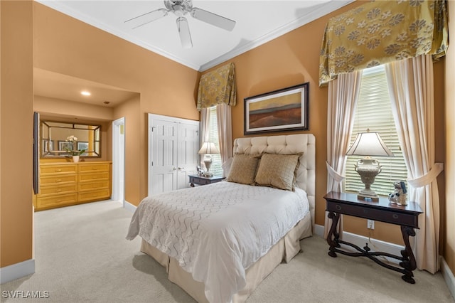 carpeted bedroom with ceiling fan, a closet, and crown molding