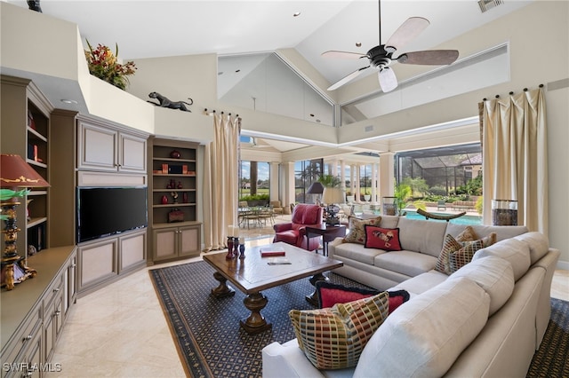 living room with a wealth of natural light, ceiling fan, and high vaulted ceiling