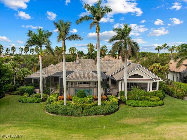 view of front of home with a lanai and a front lawn