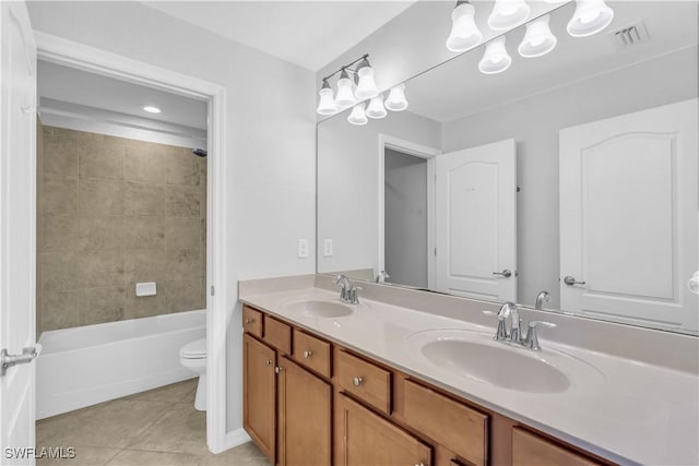 full bathroom featuring tile patterned flooring, vanity, toilet, and tiled shower / bath combo