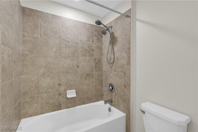 bathroom with tiled shower / bath combo and toilet