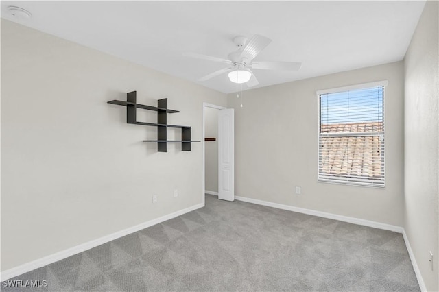 empty room featuring ceiling fan and light colored carpet