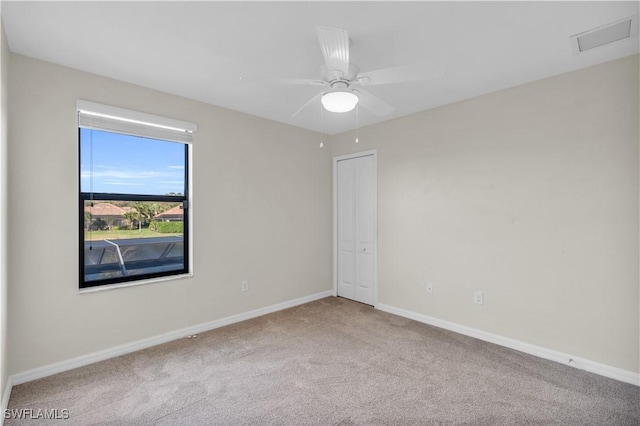 carpeted empty room featuring ceiling fan