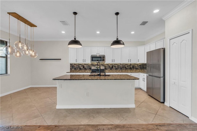 kitchen featuring white cabinetry, sink, stainless steel appliances, dark stone countertops, and a center island with sink