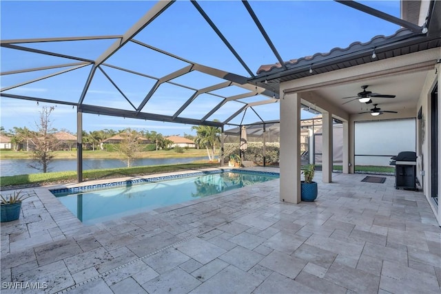 pool featuring glass enclosure, a water view, a ceiling fan, grilling area, and a patio area