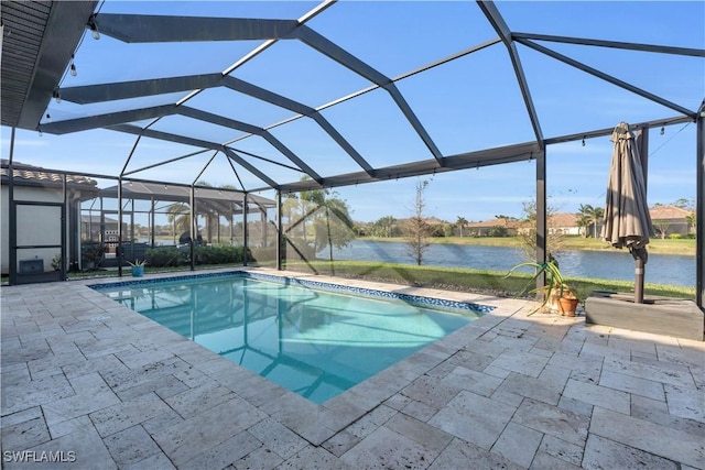 view of pool with glass enclosure, a patio area, and a water view