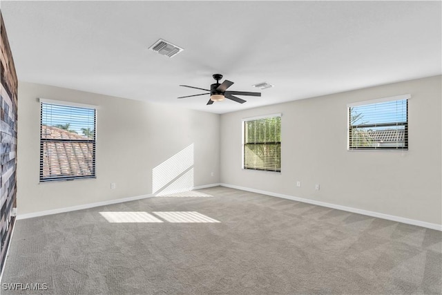 carpeted empty room with ceiling fan and a healthy amount of sunlight