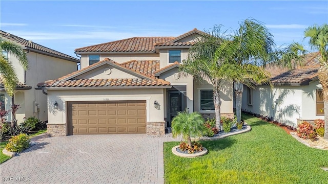 mediterranean / spanish house with a garage, stone siding, decorative driveway, stucco siding, and a front lawn