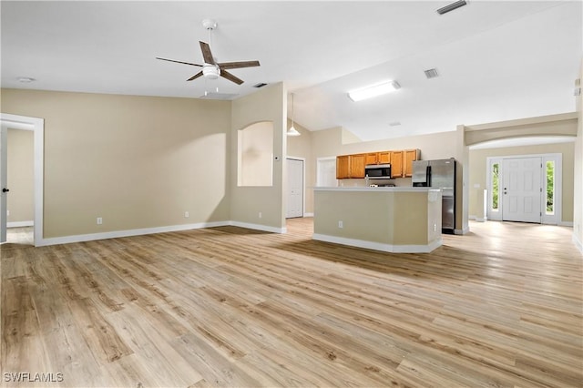 kitchen with vaulted ceiling, open floor plan, appliances with stainless steel finishes, and light wood-type flooring