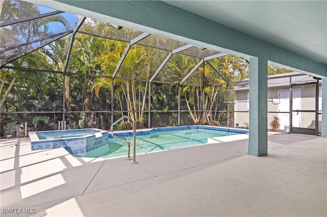 view of pool with a patio area, glass enclosure, and a pool with connected hot tub