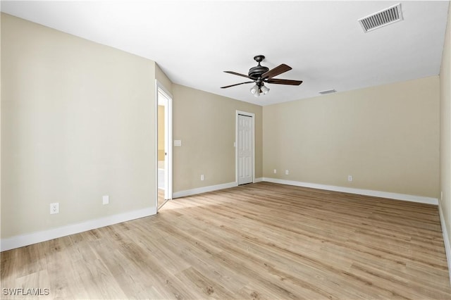 spare room featuring ceiling fan, baseboards, visible vents, and light wood-type flooring