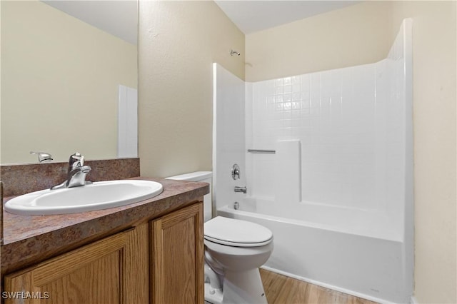 full bathroom with tub / shower combination, toilet, vanity, and wood finished floors