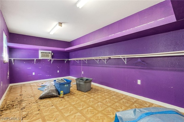 unfurnished bedroom featuring tile patterned floors, baseboards, and a wall mounted AC