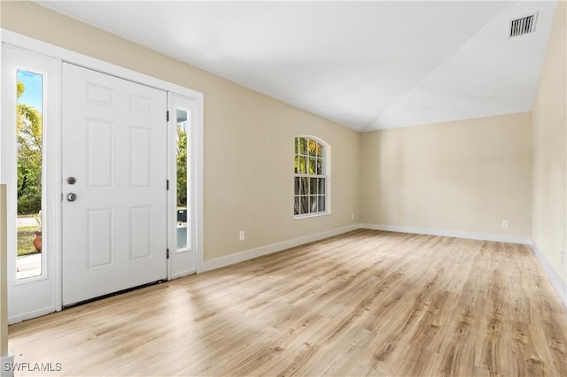 entrance foyer featuring lofted ceiling, light wood finished floors, visible vents, and a wealth of natural light