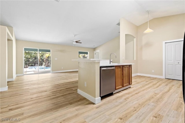 kitchen featuring open floor plan, lofted ceiling, light wood-style floors, brown cabinetry, and stainless steel dishwasher