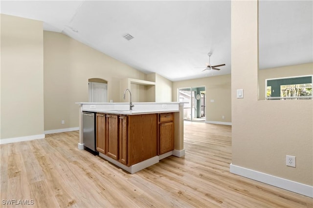 kitchen featuring brown cabinetry, visible vents, lofted ceiling, a sink, and light countertops