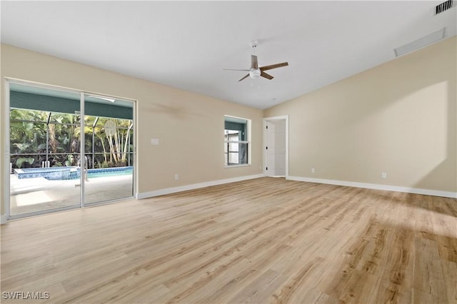 spare room featuring visible vents, light wood-style floors, ceiling fan, and vaulted ceiling