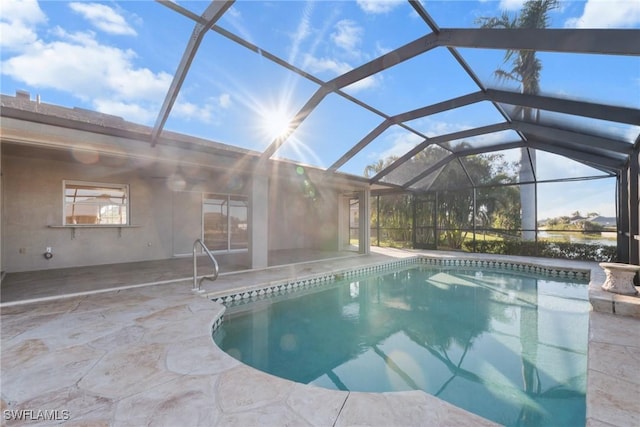 view of pool with glass enclosure and a patio