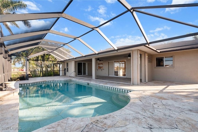 view of pool with glass enclosure, ceiling fan, and a patio